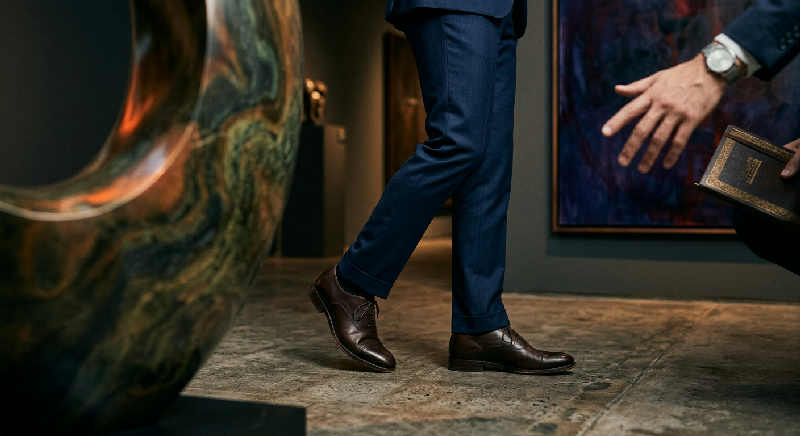 Polished concrete floors and textured stone walls in a minimalist gallery, caught in a soft, low-angle cinematic light.